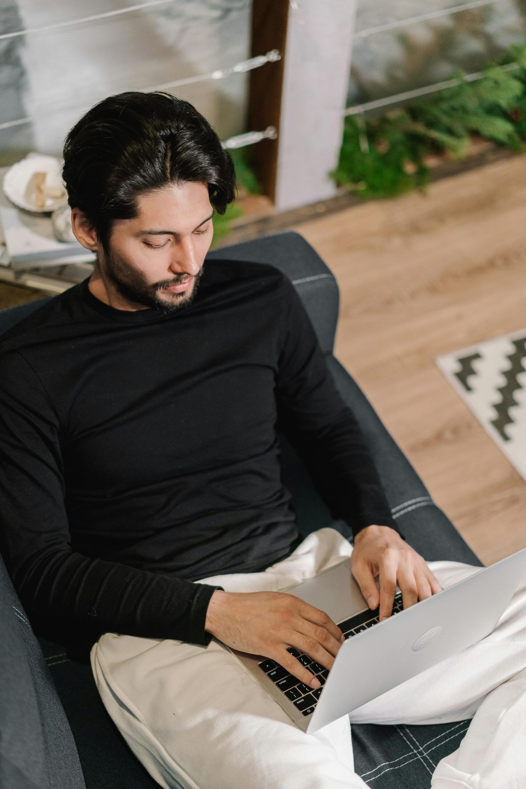 A guy sitting on a couch looking for freelance digital marketing jobs
